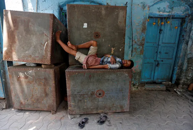 A man sleeps on a metal water storage tank on a hot summer day in Kolkata, India May 10, 2017. (Photo by Rupak De Chowdhuri/Reuters)