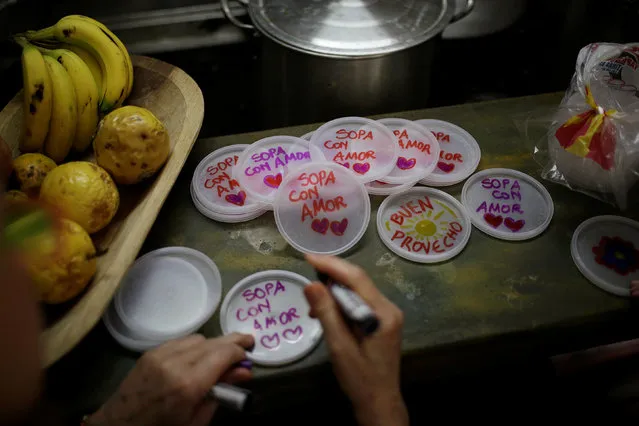Lids with messages that read “soup with love” are seen at the home kitchen of a volunteer of Make The Difference (Haz La Diferencia) charity initiative, in Caracas, Venezuela March 5, 2017. Critics say 18 years of socialist rule, exacerbated by a fall in oil prices, are to blame for Venezuela's economic collapse. But President Nicolas Maduro says he is the victim of an “economic war” waged by the country's elite and the U.S. government. “If the bourgeoisie hide the food, I myself will bring it to your house. National production should go to the people in order to defeat the imperialist war”, Maduro said at an event this month to promote the distribution of subsidized food. (Photo by Marco Bello/Reuters)