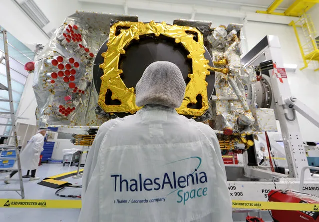 A technician stands in front of the all-electric Konnect communications satellite, which will be shipped to the Guiana Space Center in Kourou, in the clean room facilities at the Thales Alenia Space plant in Cannes, France, November 22, 2019. (Photo by Eric Gaillard/Reuters)