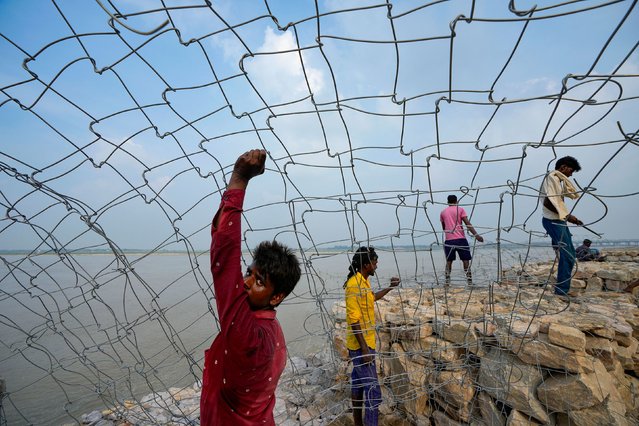 Laborers in Prayagraj, India, work on a road construction site adjacent to the Ganges River on Friday, July 26, 2024. (Photo by Rajesh Kumar Singh/AP Photo)