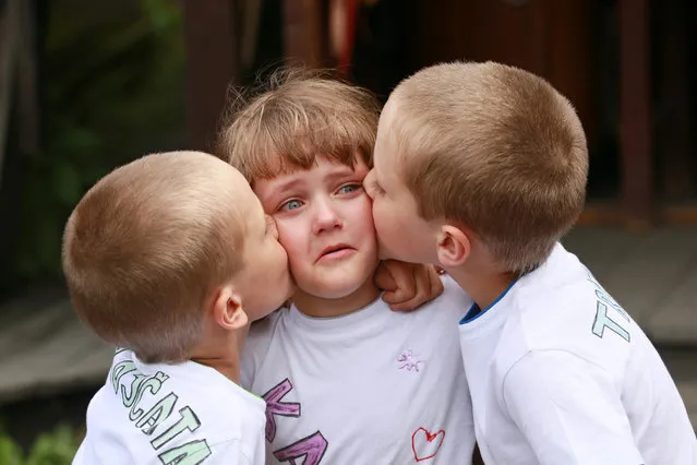 10 years old triplets Josef, Katerina And Daniel (L toR) hug each other during a meeting of twins and multiples in Zvole, Czech Republic, south Moravia, on May 29, 2016. The biggest meeting of twins and multiples in the Czech Republic was today in Zvole, 40 km east of Brno. Meeting  attended by one hundred pairs, take  a family photo. This is a unique event in the Czech Republic. (Photo by Radek Mica/AFP Photo)