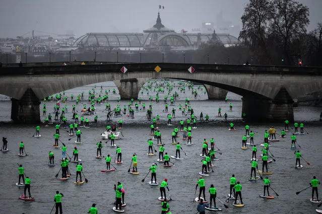 Competitors take part in the Nautic Paddle Race on the Seine river with The Grand Palais in the background in Paris on December 8, 2019. About 1000 competitors took part in the 11 kilometer race on the Seine River in the French capital. (Photo by Philippe Lopez/AFP Photo)