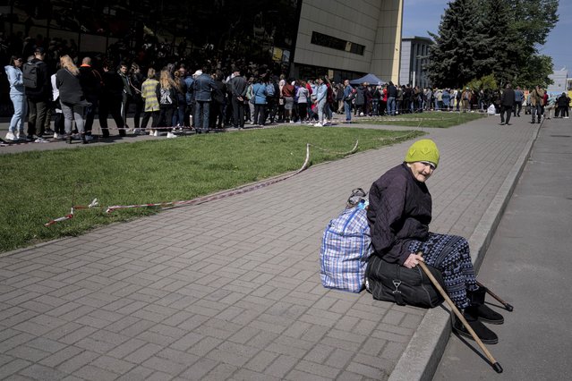 Didenko Ekaterina, 93, from the Ukrainian city of Vuhledar, waits for her daughter as people stay in line for registration at the aid distribution center for displaced people in Zaporizhia, Ukraine, Thursday, May 5, 2022. (Photo by Evgeniy Maloletka/AP Photo)