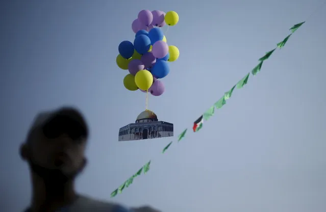 Balloons, attached to a cutout of the Dome of the Rock, are released during a military-style graduation ceremony for young Palestinians organised by the Hamas movement, in Gaza City August 5, 2015. Thousands of young Palestinians joined Hamas military-style summer camps during school vacation in the Gaza Strip to prepare them to “confront any possible Israeli attack”, organisers said. (Photo by Suhaib Salem/Reuters)