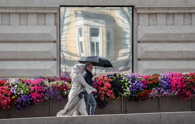 People walk along flower decorations as part of the urban landscape design festival “Summer in Moscow. Gardens and flowers” in front of Kremlin in Moscow, Russia, 05 August 2024. The festival, which displays more than 650 flower objects and 50 exhibition gardens in the city, will last until 08 September 2024. (Photo by Yuri Kochetkov/EPA/EFE)