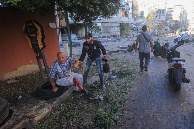 An injured resident sits on a sidewalk during Israeli airstrikes on the Mreijeh neighbourhood in Beirut's southern suburbs on October 4, 2024. (Photo by AFP Photo/Stringer)