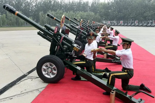 Paramilitary policemen and members of a gun salute team load cannons during a training session for a military parade to mark the 70th anniversary of the end of the World War Two, at a military base in Beijing, China, August 1, 2015. (Photo by Reuters/Stringer)