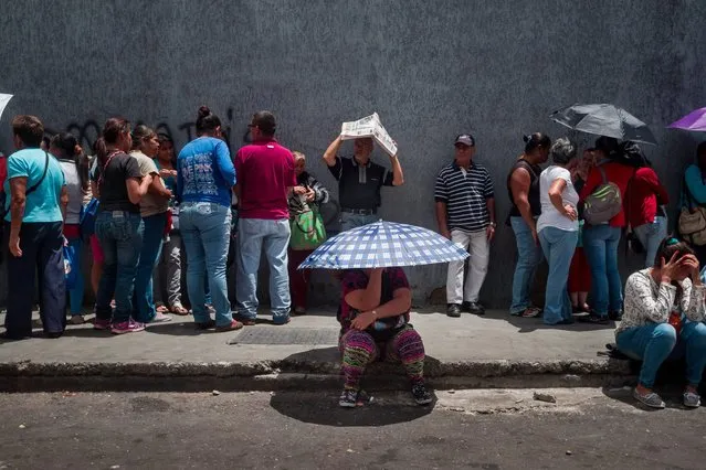 People line up to get food at a distribution point during a protest asking for food in the district of Catia in Caracas, Venezuela, 14 June 2016. New protests and looting attempts happened in several states of the country due to severe scarcity of food and medicines. (Photo by Miguel Gutierrez/EPA)