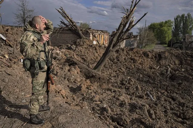 A Ukrainian serviceman inspects a site after an airstrike by Russian forces in Bahmut, Ukraine, Tuesday, May 10, 2022. (Photo by Evgeniy Maloletka/AP Photo)