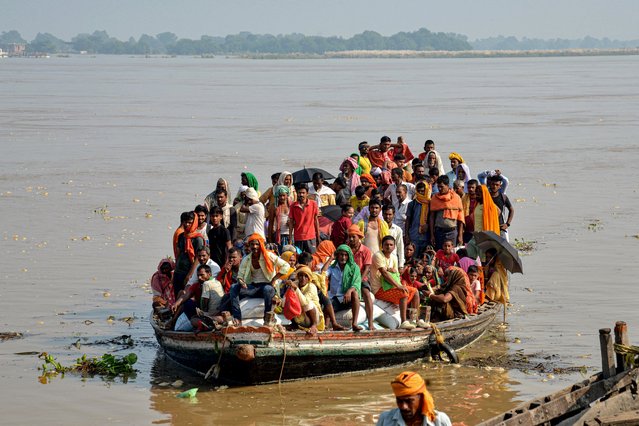 Flood-affected people along with their belongings, move to a safer place in a boat after rise in the water level of river Ganges following heavy rains, in Patna on September 23, 2024. (Photo by Sachin Kumar/AFP Photo)