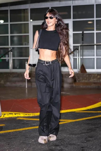 Bella Hadid is all smiles while leaving a photoshoot at Pier 59 in New York City on June 2, 2022. The 25 year old supermodel wore a black crop top, matching trousers with gold and white trainers. (Photo by The Image Direct)