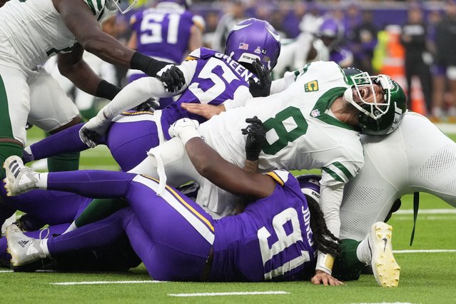 New York Jets quarterback Aaron Rodgers (8), right, reacts as he is tackled during the second half of an NFL football game against the Minnesota Vikings, Sunday, October 6, 2024, at the Tottenham Hotspur stadium in London. (Photo by Kirsty Wigglesworth/AP Photo)