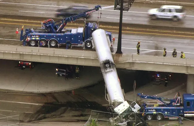 In this photo from video provided by KMOV-TV, emergency responders work to lower a tanker truck to the ground after it crashed off an Interstate 44 overpass in downtown St. Louis, Thursday, July 27, 2017. (Photo by KMOV-TV via AP Photo)