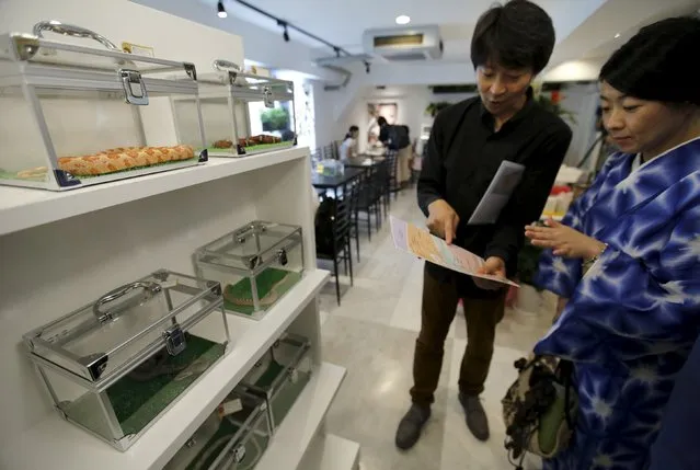 A customer chooses snakes  at the Tokyo Snake Center, a snake cafe, in Tokyo's Harajuku shopping district  August 14, 2015. (Photo by Toru Hanai/Reuters)