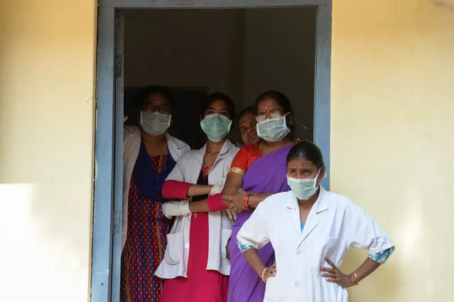 Medical staff, wearing protective face masks, watch a Health Ministry team visit an isolation ward, where patients coming from Hong Kong are kept a preventative measure following a SARS-like virus outbreak which began in the Chinese city of Wuhan, at a governement run Fever Hospital in Hyderabad, on January 28, 2020. The epidemic, which experts believe emanated from a wild animal market in the city of Wuhan last month, has spread around China and to more than a dozen other countries despite the extraordinary travel curbs. (Photo by Noah Seelam/AFP Photo)