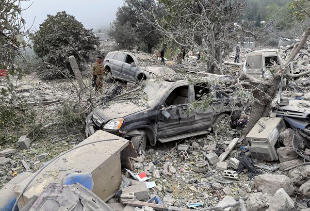 Lebanese army soldier stands near destroyed vehicles at a site damaged by an Israeli air strike in the Christian-majority region of Aitou in north Lebanon, the Lebanese health ministry said, on October 14, 2024. (Photo by Omar Ibrahim/Reuters)