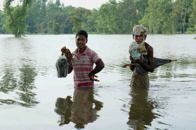 Bangladeshi walk in water in an area submerged by flood in Kurigram, northern Bangladesh on August 14, 2017. At least 175 people have died and thousands have fled their homes as monsoon floods swept across Nepal, India and Bangladesh, officials said on August 14, warning the toll could rise as the extent of the damage becomes clear. (Photo by AFP Photo/Stringer)