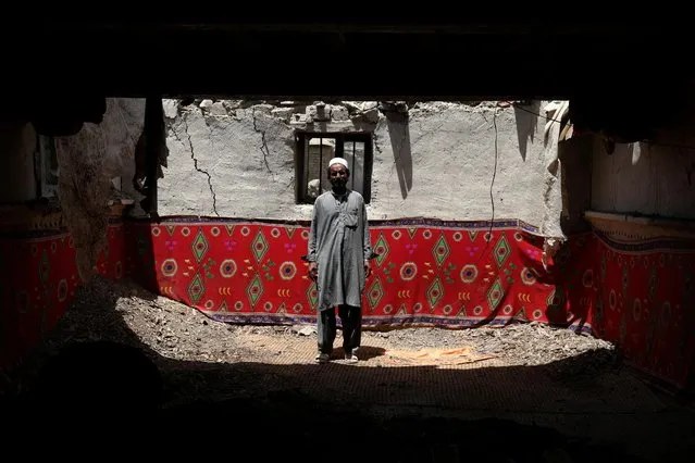 Ahmad Vali poses for a picture inside his house that was damaged by an earthquake in Gayan, Afghanistan, June 23, 2022. (Photo by Ali Khara/Reuters)
