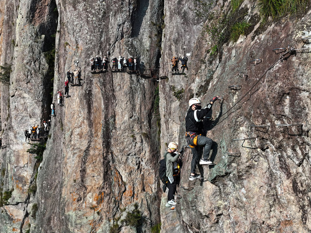 Tourists challenge themselves along the Via Ferrata paths at Yandang Mountain scenic area on October 20, 2024 in Wenzhou, Zhejiang Province of China. (Photo by Cai Kuanyuan/VCG via Getty Images)