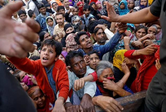 People crowd to receive free grocery items being distributed outside a relief camp after they fled their homes following Hindu-Muslim clashes triggered by a new citizenship law, in Mustafabad in the riot-affected northeast of New Delhi, India, March 3, 2020. (Photo by Anushree Fadnavis/Reuters)