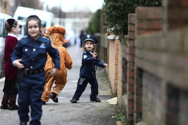 Jewish children in fancy dress costumes run in the street as they celebrate the annual holiday of Purim in Stamford Hill in London, Britain on March 10, 2020. (Photo by Simon Dawson/Reuters)