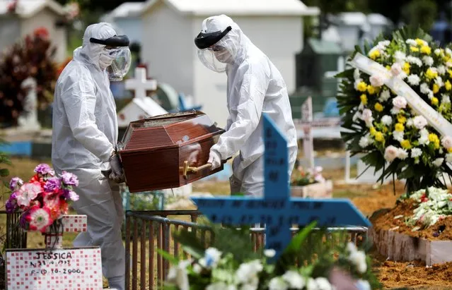 Gravediggers wearing protective suits carry the coffin of 68-years-old Natalina Cardoso Bandeira, who passed away due to coronavirus disease (COVID-19), at the Parque Taruma cemetery in Manaus, Brazil, April 10, 2020. (Photo by Bruno Kelly/Reuters)