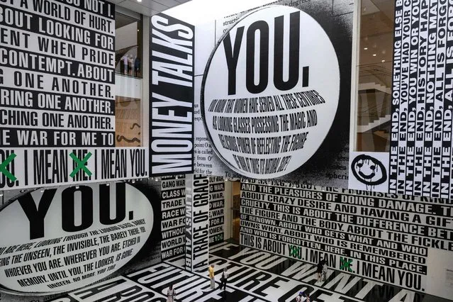 Visitors look at the “Thinking of You. I Mean Me. I Mean You.” installation by US artist Barbara Kruger at The Museum of Modern Art (MoMA) in New York on August 3, 2022. The installation, in MoMA's Marron Family Atrium, explores power and popular culture. (Photo by Angela Weiss/AFP Photo)