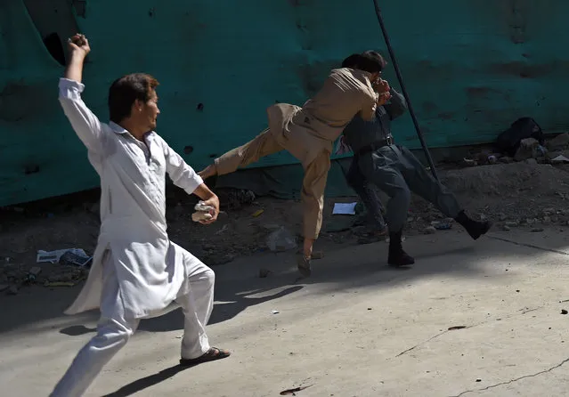 Afghan protesters beat a policeman after a suicide attack that targeted crowds of minority Shiite Hazaras during a demonstration at the Deh Mazang Circle of Kabul on July 23, 2016. Islamic State jihadists claimed responsibility for twin explosions July 23 that ripped through crowds of Shiite Hazaras in Kabul, killing at least 61 people and wounding 207 others in apparently their deadliest attack in the Afghan capital. The bombings during a huge protest over a power transmission line could deepen sectarian divisions in a country well known for communal harmony despite decades of war. (Photo by Wakil Kohsar/AFP Photo)