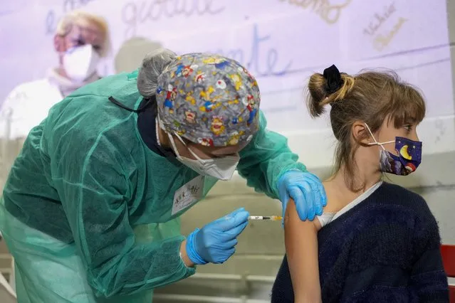 A girl receives a dose of Pfizer-BioNTech COVID-19 vaccination for children aged 5 - 11, in Rome, Wednesday, December 15, 2021. Italy has started vaccinating children aged 5-11 against COVID-19 as the government braces for the spread of the omicron variant during the holiday season. (Photo by Andrew Medichini/AP Photo)