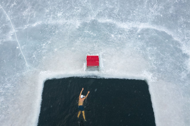 An aerial drone photo taken on January 1, 2025 shows a winter swimming enthusiast swimming in Harbin, northeast China's Heilongjiang Province. People across China enjoy themselves in various activities, celebrating the first day of 2025. (Photo by Xinhua News Agency/Rex Features/Shutterstock)