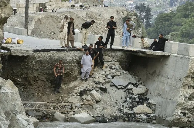 Local residents and police stand in the damaged road destroyed by floodwaters in Kalam Valley in northern Pakistan, Sunday, September 4, 2022. Several countries have flown in supplies, but the Pakistani government has pleaded for even more help, faced with the enormous task of feeding and housing those affected, as well as protecting them from waterborne diseases. (Photo by Sherin Zada/AP Photo)