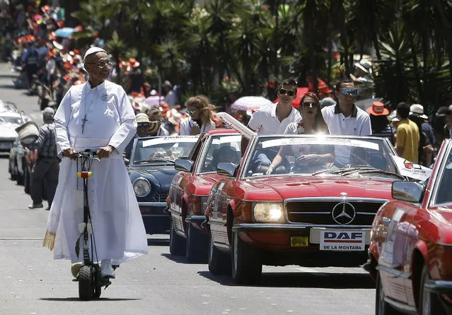 A man dressed as Pope Fracis (L) takes part in the “Parade of Classic and Vintage Cars” at the 59th Fair of Flowers in Medellin, Antioquia, Colombia, 06 August 2016. The annual Fair of Flowers expects the attendance of more than 24,000 visitors and will run until 07 August. (Photo by Luis Eduardo Noriega/EPA)