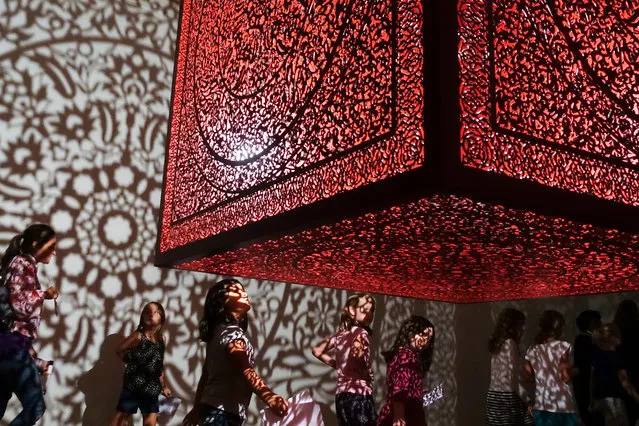 Visitors browse an installation of Pakistani-American artist Anila Agha's “All the Flowers are for Me” at the Cincinnati Art Museum, Sunday, October 15, 2017, in Cincinnati. The piece draws its shadow casts from Islamic architectural styles and is meant to reflect artist's separation from her roots in Pakistan as she lives in the United States. (Photo by John Minchillo/AP Photo)