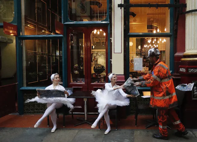 Actors dressed up sit in the streets of Leadenhall Market in London, Tuesday, October 24, 2017. A Large-scale artwork was unveiled accompanied by characters to tell the story of London's world-famous insurance market in a three day-campaign that aims to explain how London insurers and brokers support people, businesses, charities and governments all round the world. (Photo by Frank Augstein/AP Photo)