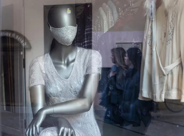 A mannequin dressed in a face mask is placed in the window of a clothing store in Vilnius, Lithuania, Friday, May 22, 2020. The Lithuanian government extended the nationwide coronavirus quarantine until May 31, but gave the green light for museums, libraries, cafes, restaurants, hairdressers and beauty salons, and retail stores in shopping malls to reopen. (Photo by Mindaugas Kulbis/AP Photo)