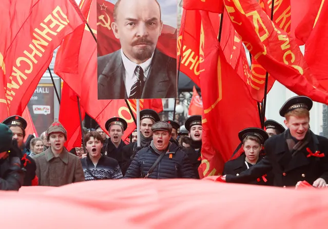 Demonstrators carry flags and a portrait of Soviet state founder Vladimir Lenin during a rally held by Russian Communist party to mark the Red October revolution's centenary in central Moscow, Russia on November 7, 2017. (Photo by Sergei Karpukhin/Reuters)