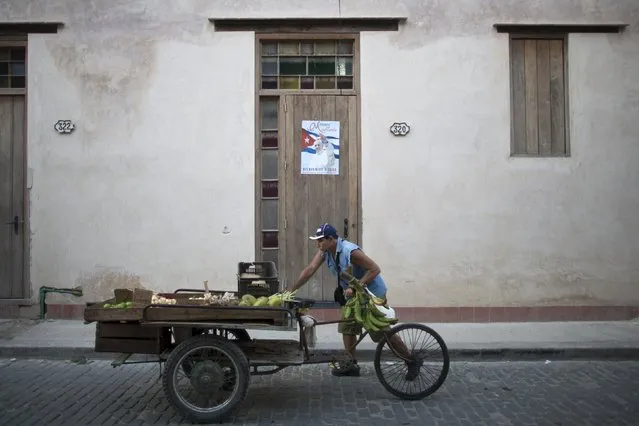 A street vendor passes by a poster advertising the visit of Pope Francis to Cuba in downtown Havana, September 4, 2015. (Photo by Alexandre Meneghini/Reuters)