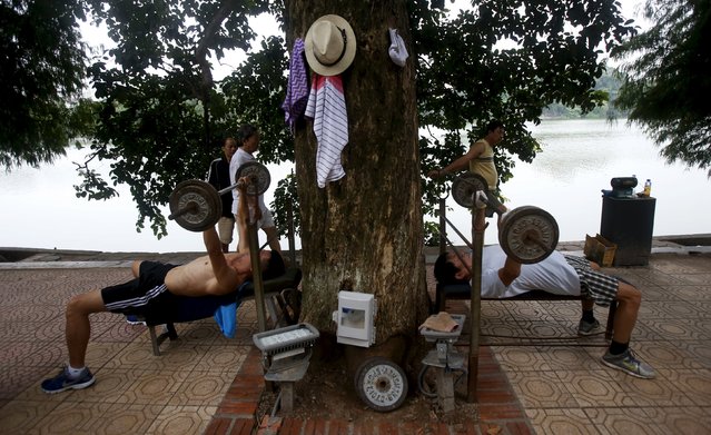 Residents lift weights during a morning exercise beside the Hoan Kiem Lake in Hanoi, Vietnam, September 15, 2015. (Photo by Reuters/Kham)