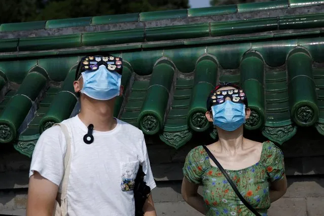 People wear face masks and protective glasses to observe the partial solar eclipse at the Temple of Heaven park in Beijing, China on June 21, 2020. (Photo by Tingshu Wang/Reuters)