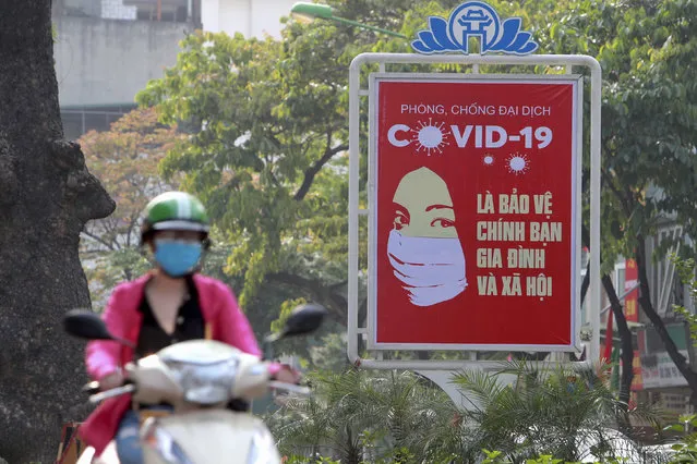 In this April 14, 2020 file photo, a motorcyclist drives past a poster calling people to take care of their health against the new coronavirus in Hanoi, Vietnam. Nervous travelers, spotty air service, health risks _  the battered global tourism industry is facing unprecedented uncertainty in the wake of the new coronavirus. Millions of workers are laid off or furloughed, and it will likely take years for the industry to get back to the strong demand it was seeing just six months ago. (Photo by Hau Dinh/AP Photo)