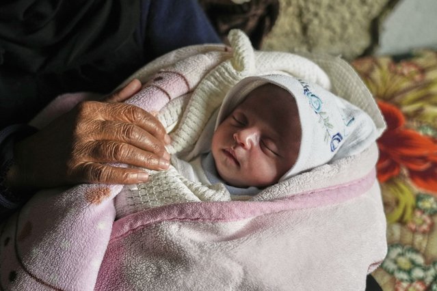 Ella Osama Abu Dagga, 25 days old, is held by her great-aunt Suad Abu Dagga, after she was pulled from the rubble earlier following an Israeli army airstrike that killed her parents and brother, in Khan Younis, southern Gaza Strip, Thursday, March 20, 2025. (Photo by Abdel Kareem Hana/AP Photo)