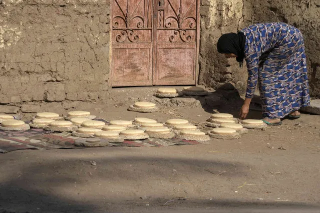 An Egyptian woman prepare to bake bread, traditionally known as sun bread, at the Valley of the Kings in Luxor, Egypt, Friday, November 4, 2022. Egypt will host the COP27 U.N. Climate Summit on Nov. 6, and is scheduled to end on Nov. 18. (Photo by Amr Nabil/AP Photo)