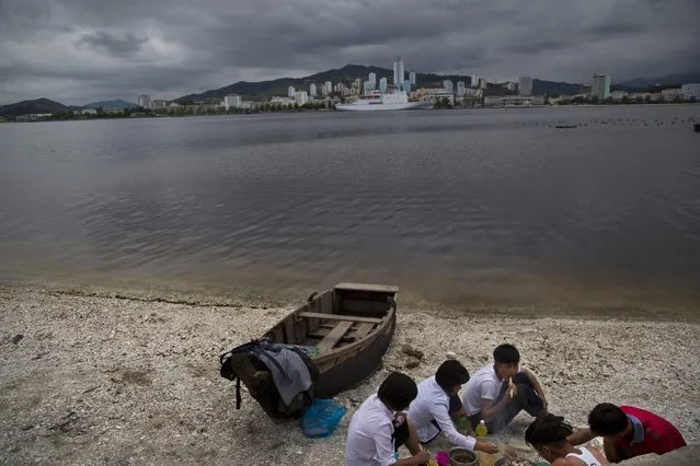 In this June 21, 2014 photo, a group of young North Koreans enjoys a picnic on the beach in Wonsan, North Korea. (Photo by David Guttenfelder/AP Photo)