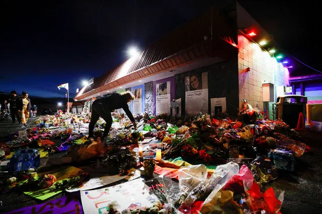 A person lights a candle left at the memorial in front of Club Q after a mass shooting at the LGBTQ nightclub, in Colorado Springs, Colorado, U.S. November 26, 2022. (Photo by Isaiah J. Downing/Reuters)