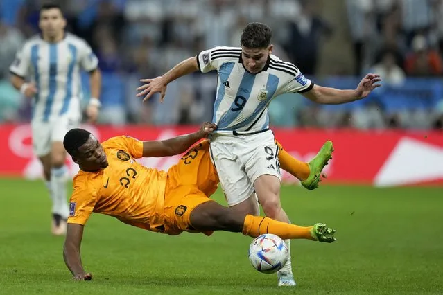 Denzel Dumfries of the Netherlands tries to tackle Argentina's Julian Alvarez, right, during the World Cup quarterfinal soccer match between the Netherlands and Argentina, at the Lusail Stadium in Lusail, Qatar, Friday, December 9, 2022. (Photo by Ricardo Mazalan/AP Photo)