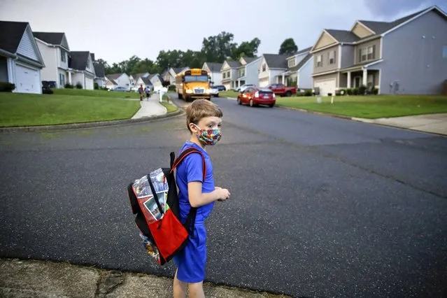 Paul Adamus, 7, waits at the bus stop for the first day of school on Monday, Aug. 3, 2020, in Dallas, Ga. Neighboring states arrived at differing conclusions on who's in charge of the reopening of schools. The differences in philosophy underscore some of the difficulties facing states as they grapple with how to proceed amid growing coronavirus infections in numerous states. (Photo by Brynn Anderson/AP Photo)