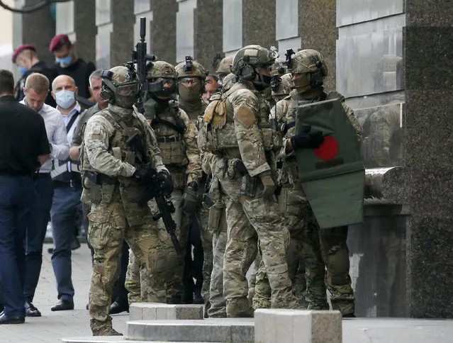 Ukraine's special police prepare to storm a city bank in Kyiv, Ukraine, Monday, August 3, 2020, after a man has threatened to blow up an explosive device inside the bank. The man, identified as Sukhrob Karimov, a 32-year-old citizen of the Central Asian nation of Uzbekistan, entered a bank office in Kyiv and said he had explosives in his backpack. He let bank clerks go and demanded that the authorities invite journalists so that he could make a statement. (Photo by Efrem Lukatsky)/AP Photo