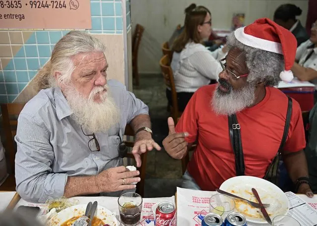 Professional Santas from Brazil's Santa Claus school talk during a Santa Claus reunion called “Barbas de Molho” (Beards at rest) at a restaurant in Rio de Janeiro, Brazil, on December 26, 2022. (Photo by Carl de Souza/AFP Photo)