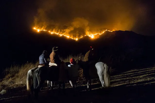 Local villagers observe wildfires from Casa Grande community on August 25, 2020 in Cordoba, Argentina. Wildfires are raging Argentina's Cordoba province threatening to destroy homes and forcing evacuations in some areas. Cause of the fires, fueled by winds and droughts, has not been determined yet but Justice suspects of ranchers setting fire to clear areas for new crops. (Photo by Sebastian Salguero/Getty Images)