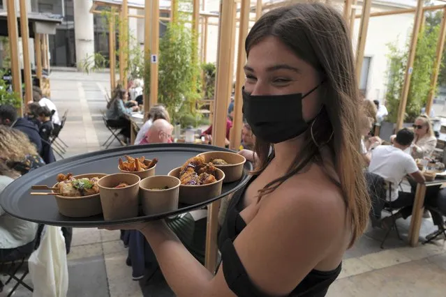 A waitress of The Palais de Tokyo restaurant wears a protective face mask as a precaution against the coronavirus in Paris, Saturday, September 5, 2020. New French cases of COVID-19 jumped in 24 hours to nearly 9,000, health officials said Friday. The 8,975 new cases were the highest number of infections since France successfully grappled with the spread of the coronavirus during a strict two-month lockdown. There were some 1,800 cases less a day earlier and more than for European neighbors. (Photo by Francois Mori/AP Photo)